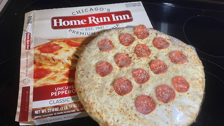 Sparsely spaced pepperonis top a frozen pizza which sits on a Chicago's Home Run Inn pizza box.