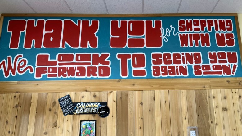 Trader Joe's hand-painted sign above exit reading "Thank you for shopping with us"