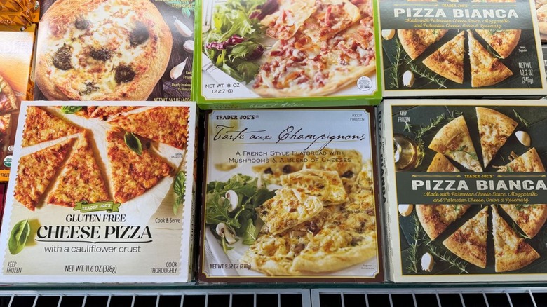 Boxes of frozen pizzas in Trader Joe's freezer section including gluten free cheeze and pizza pianca