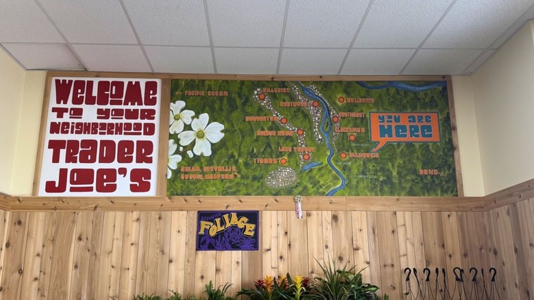 Entrance to Trader Joe's location with hand-painted sing that reads "Welcome to your neighborhood Trader Joe's"