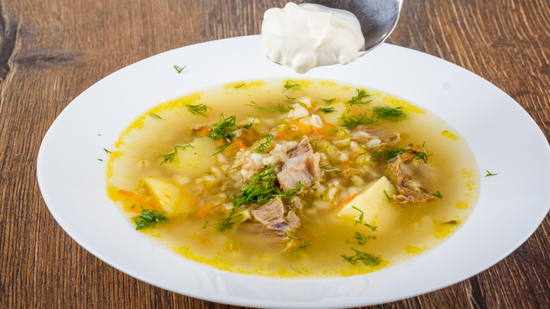 Adding sour cream to freshly prepared soup