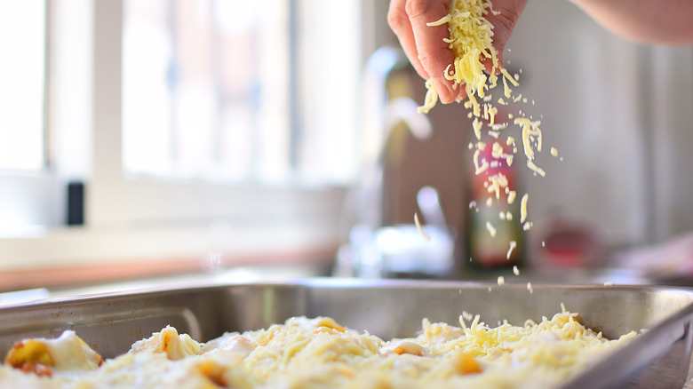 Adding some cheese and béchamel sauce to an Italian pasta