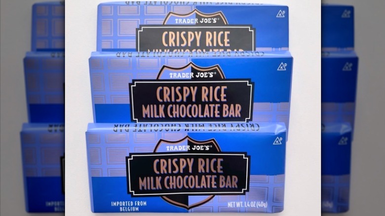 Three bars of Trader Joe's Crispy Rice Milk Chocolate Bars on a white background.