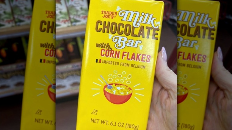 A bar of Trader Joe's Milk Chocolate with Corn Flakes held in hand in the store.