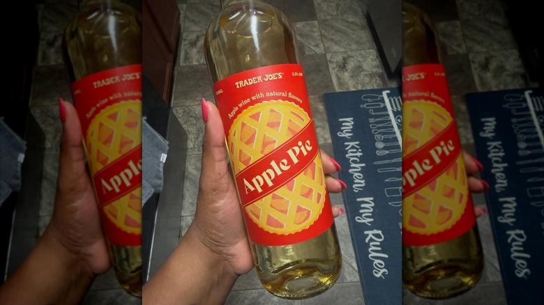 Hand holding a bottle of Trader Joe's Apple Pie Wine