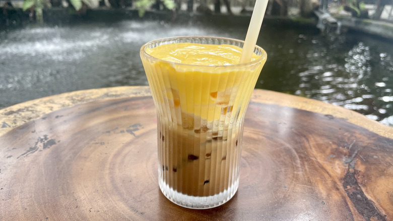 Egg coffee over ice on table overlooking koi pond
