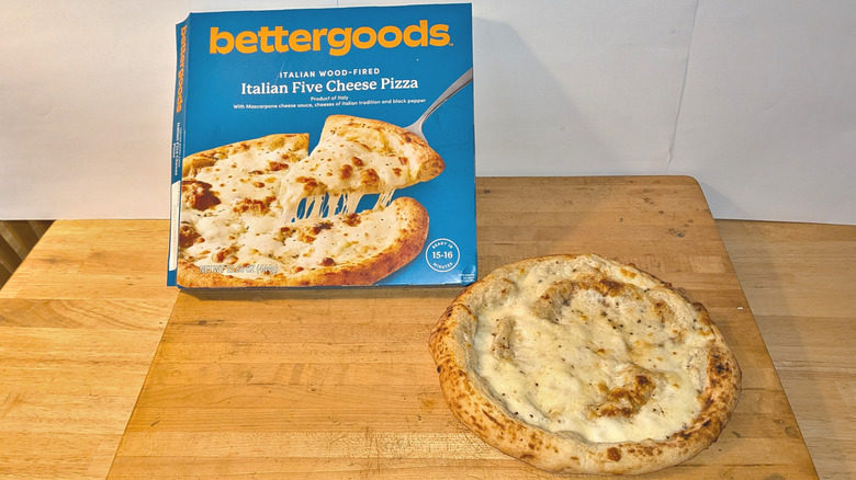 A freshly cooked bettergoods wood-fired Italian five cheese pizza beside the box it came in