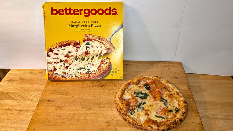 A freshly cooked bettergoods wood-fired Margherita pizza beside the box it came in