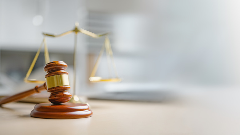 wooden gavel with blurry scales of justice in backround