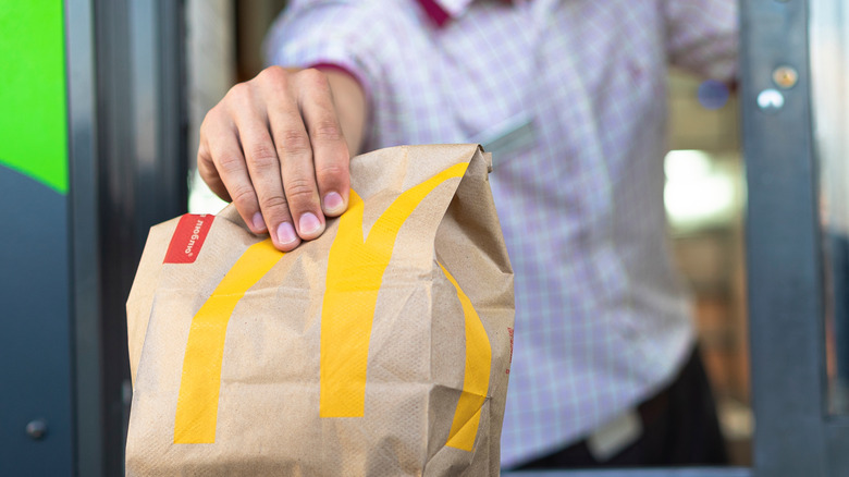 McDonald's employee passing bag out of drive-thru window