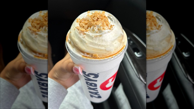 Hand holding a Zaxby's Cookie Butter milkshake in a to-go cup