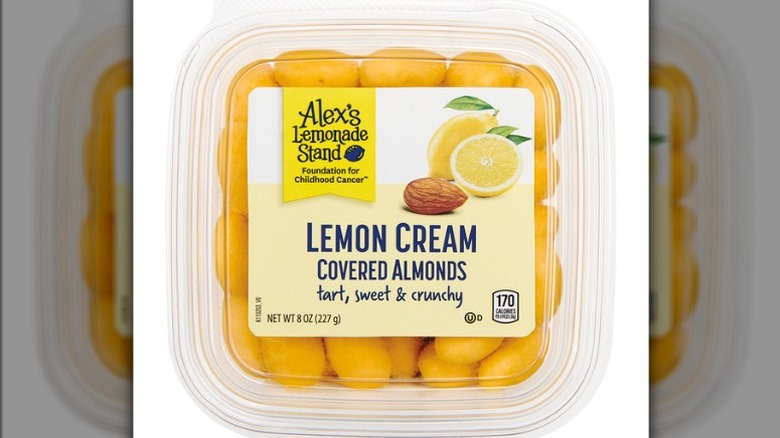 Plastic container of Aldi Choceur White Chocolate Lemon Almonds on a white background.