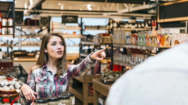 woman shopper pointing at something she wants in a grocery store