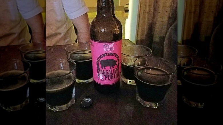 Right Brain Brewery Mangalitsa Pig Porter bottle surrounded by filled glasses on a table