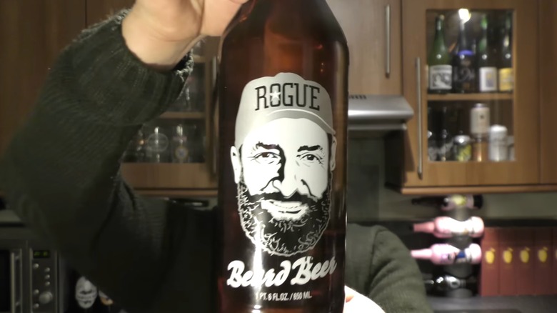 A bottle of Rogue Ales Rogue Beard Beer close-up, covering the face of the person holding it