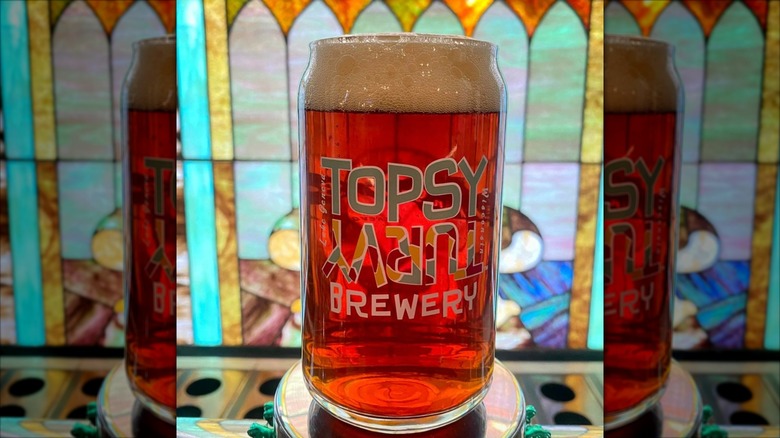 glass of Topsy Turvy Brewery beer with logo brand on glass mug