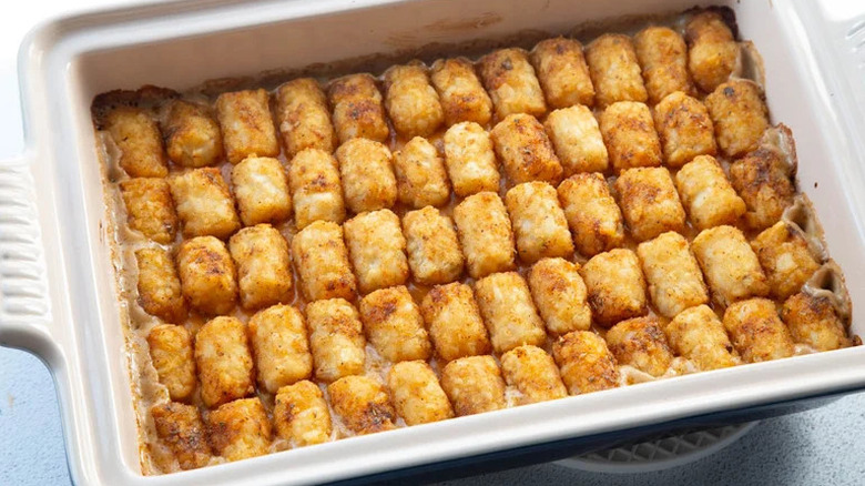 Homemade Funeral Potatoes Casserole with Tatertots on a white plate