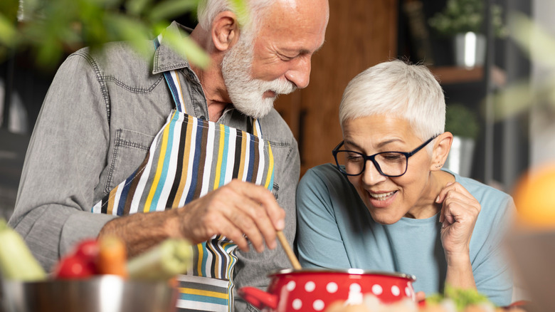 Smiling senior couple cooking together