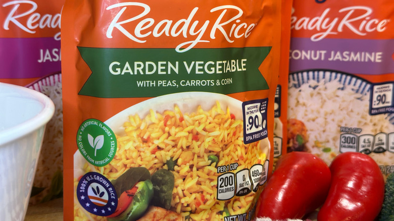 Ben's Original Ready Rice pouch in the Garden Vegetable variety next to two peppers