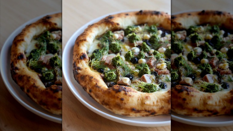 A blistered, Neapolitan style pizza with tuna, olives, and fresh dill from Pizzeria Sei restaurant