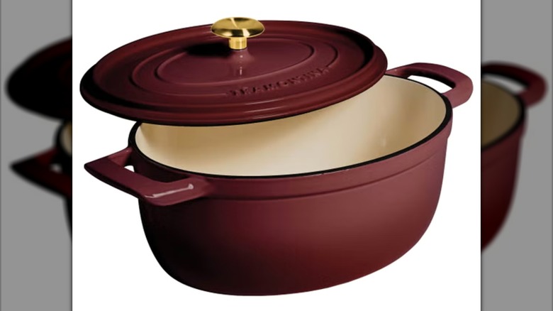 Tramontina 7-Quart Oval Enameled Cast Iron Dutch Oven with half open lid on white background