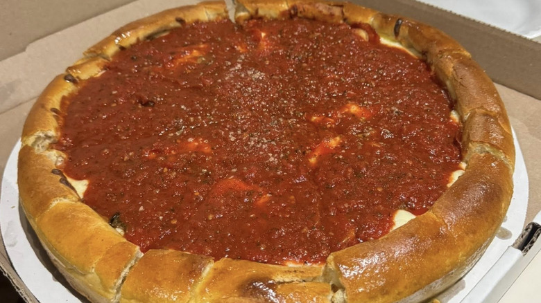 A Chicago-style pizza from Meister's Bar inside of a cardboard pizza box