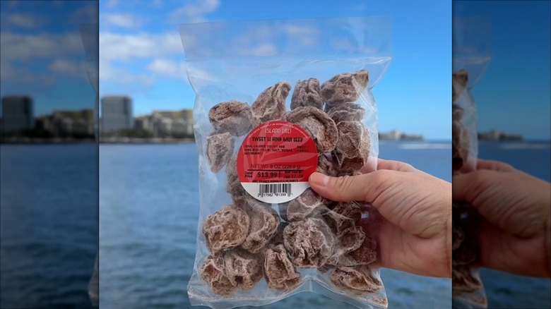 Package of Li Hing Mui from the ABC store in Hawaii, held in front of the ocean