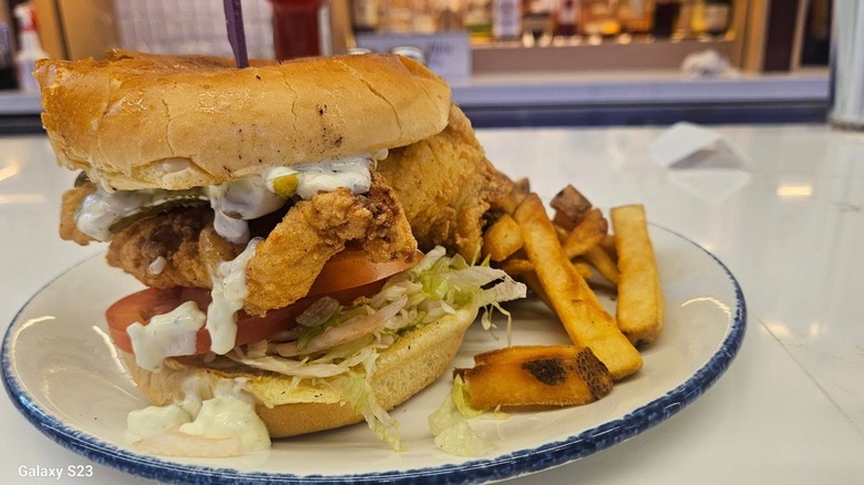 Legal Seafood crispy fish sandwich on a plate with a side of fries
