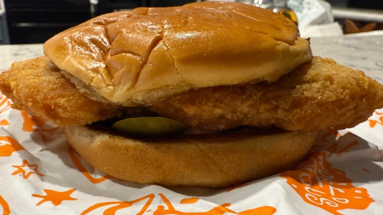 A Popeye's Cajun Flounder Fish Sandwich on a wrapper.
