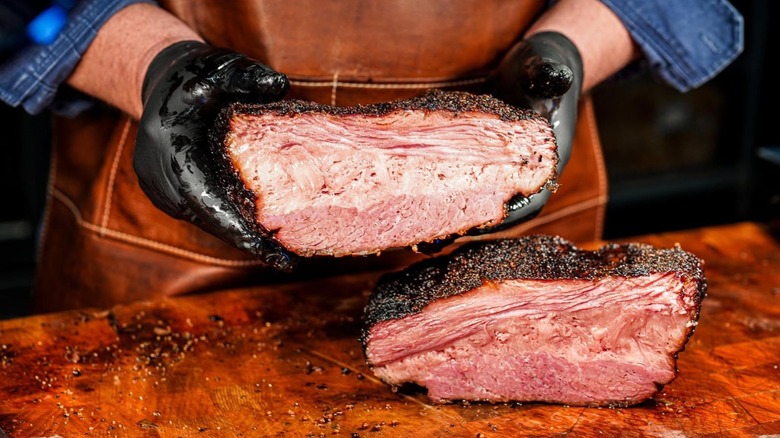 gloved hands holding freshly sliced BBQ at Bringle's Smoking Oasis