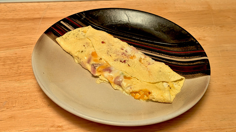 A microwaved omelet of ham and cheese on a plate