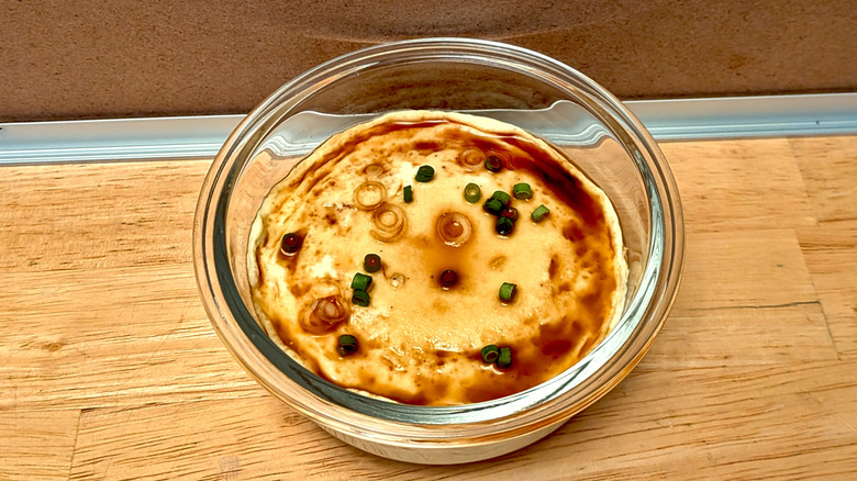 A microwaved steamed custard egg topped with soy sauce and green onion