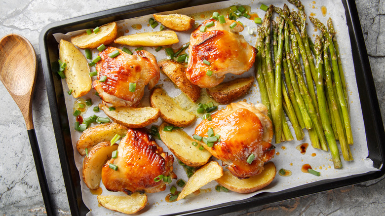 Baked chicken thighs with potato wedges and asparagus