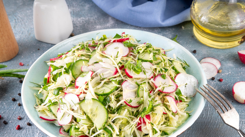 Cabbage in herb and garden salad in a white bowl