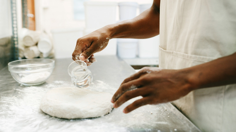 Closeup of hands following a bread recipe