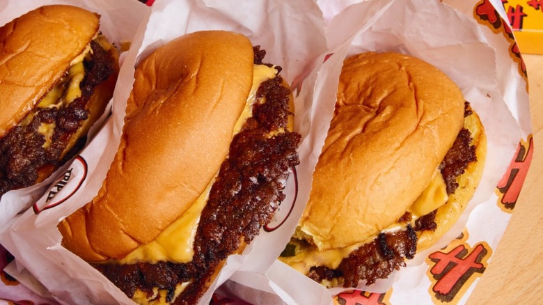Three cheeseburgers in wrappers with HH logo on it from Heavy Handed