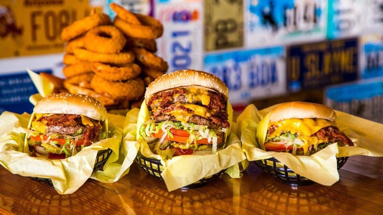 Hodad's burgers on to-go wrappers and baskets on table in front of onion rings blurred in background