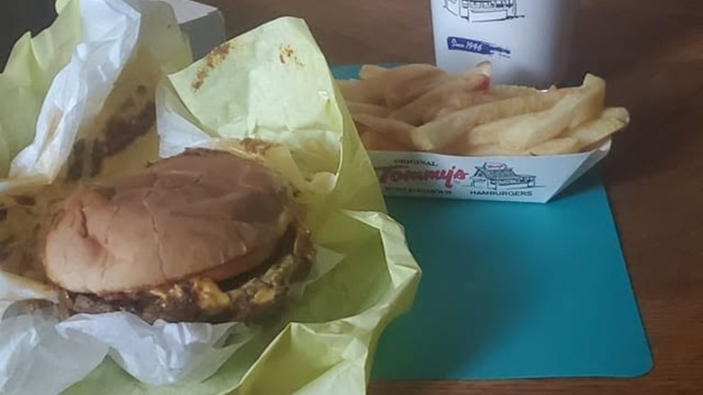 Hamburger with basket of fries on table at Original Tommy's