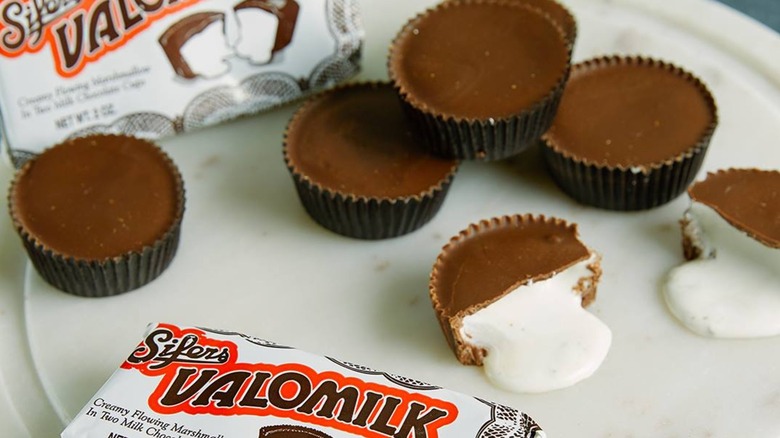 Valomilk candies with one split in half with marshmallow filling showing