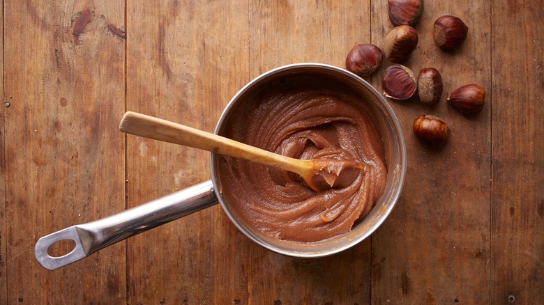 Preparing chestnut cream on a pot on wooden table, overhead shot