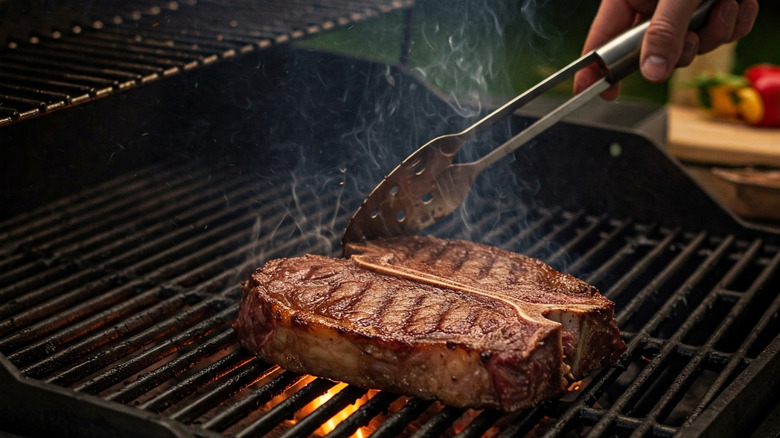 Tongs poking steak on grill