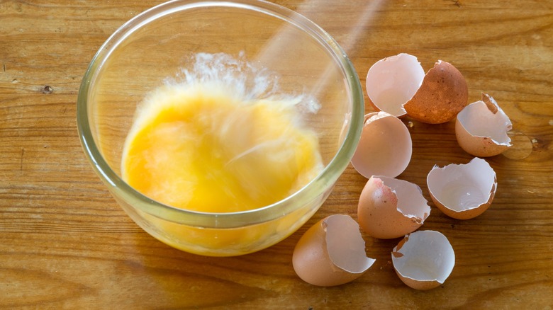 Eggs being beaten in small glass bowl