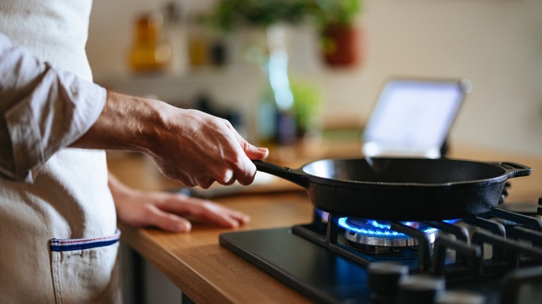 Chef hand shown taking skillet off direct heat