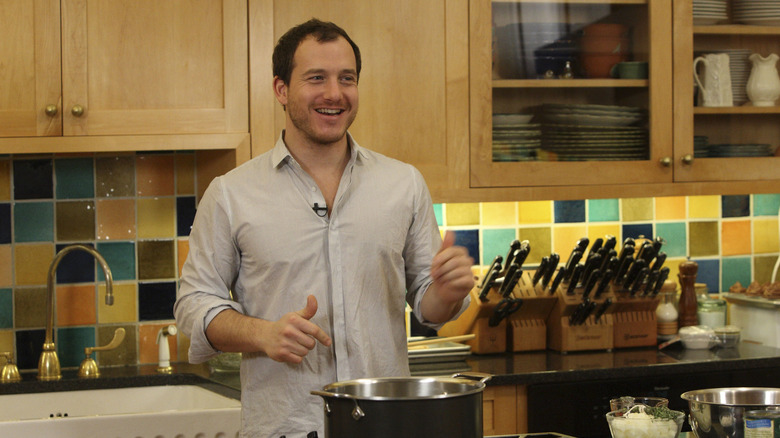 Chef Dave Lieberman cooking in a TV kitchen, smiling off to the side