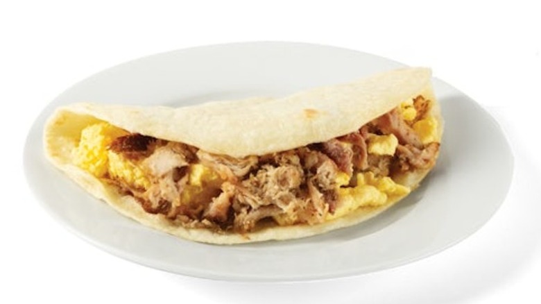 Taco Cabana Hickory Smoked Breakfast Taco on a white plate on a white background.