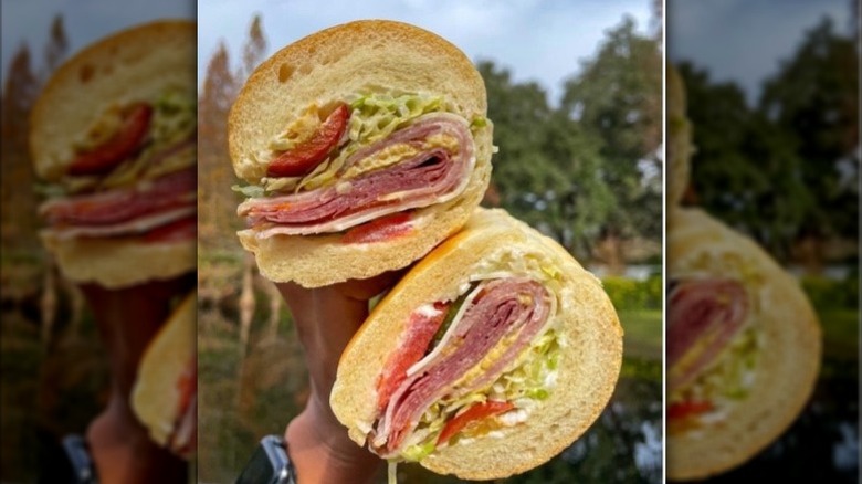 A customer holding a Jimmy John's Italian Night Club.