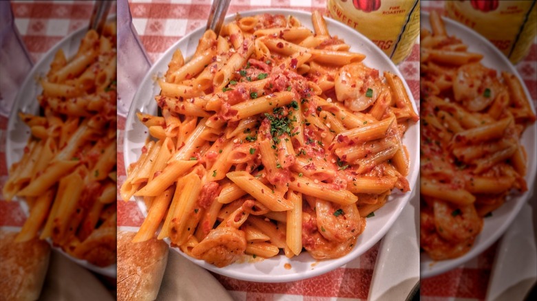 penne pasta in a red sauce with shrimp on table at Buca di Beppo