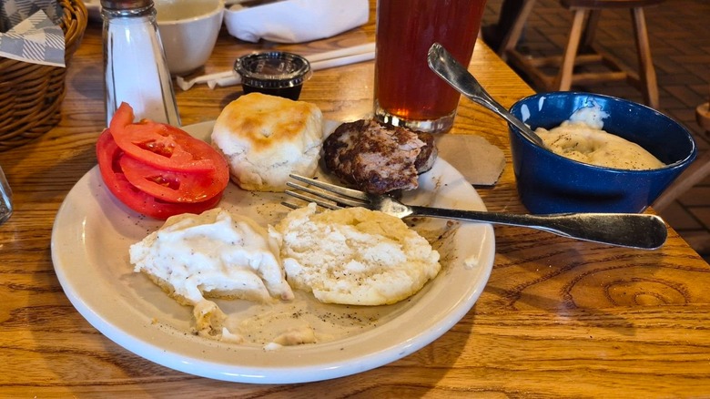 Biscuit breakfast with two biscuits, turkey sausage, sliced tomatoes, and a bowl of country gravy at Cracker Barrel Old Country Store