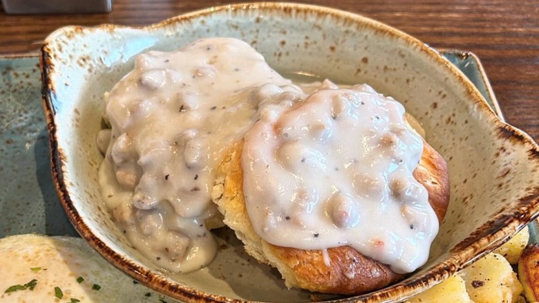 Biscuits covered in white gravy in a blue dish at First Watch
