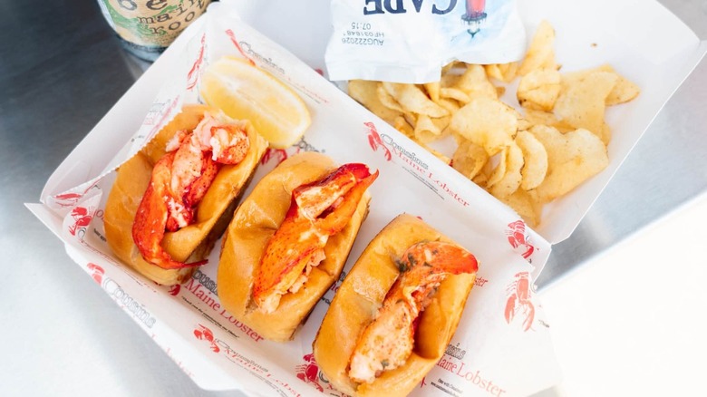 Three lobster rolls with a side of potato chips at Cousins Maine Lobster